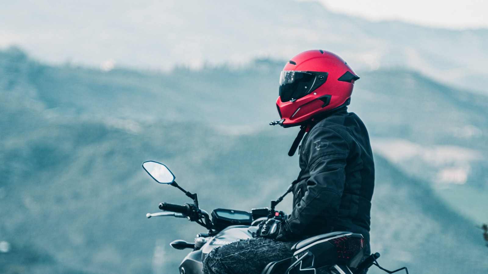 Motorradfahrer mit Helm unterwegs in den Bergen — ECE 22.05 Helme dürfen weiter gefahren werden
